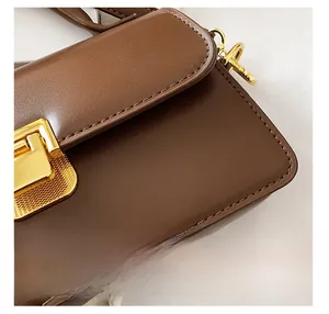 Dettaglio della borsa in pelle marrone con chiusura in metallo dorato e cuciture