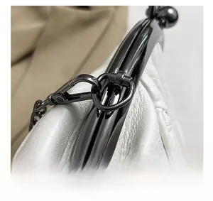 Detail of gunmetal chain link and hardware on white quilted leather seashell bag