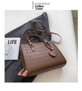 Detail of coffee brown quilted tote bag with golden hardware and heart charm