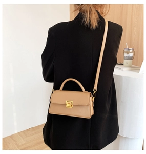 Modella che indossa una borsa kaki rettangolare con fibbia dorata e manico chic