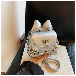 Macro shot of silver metallic mini bag with oversized bow and chunky chain detail