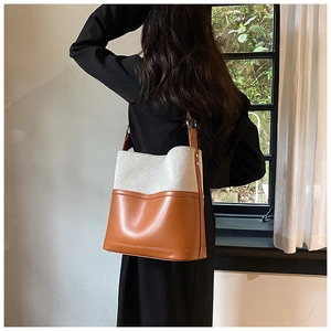 Detail of canvas and leather bucket bag with metallic ring and adjustable strap