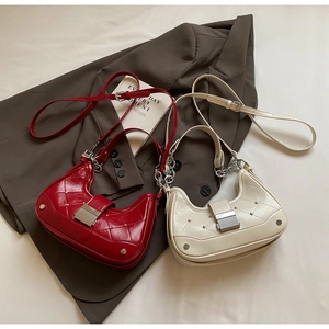 Detail of red and beige crescent bags with quilted texture and silver chain straps