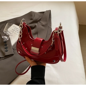 Detail of red quilted leather underarm bag with silver chain strap and metal buckle