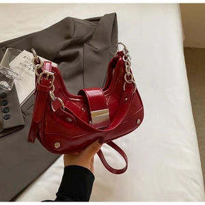 Detail of red quilted leather hobo bag with silver chain handle and metallic clasp