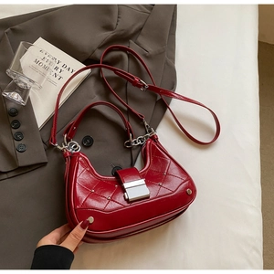 Detail of dark red quilted leather hobo bag with silver studs and chain strap