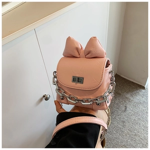 Close-up of pink mini box bag with 3D bow detail and chunky silver chain strap