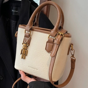 Sac seau vintage beige et marron en similicuir avec un pendentif ours métallique
