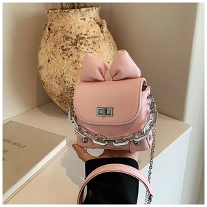 Close-up of pink mini box bag with textured PU leather, metal chain, and bow detail