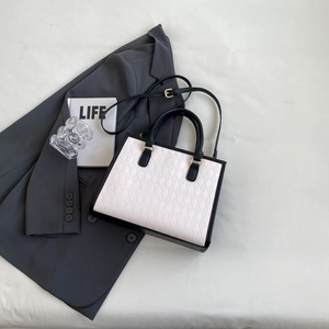 Chic black and white quilted tote bag with golden hardware and adjustable shoulder strap