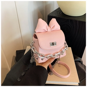 Pink mini box bag with silver chunky chain and decorative bow held by a model