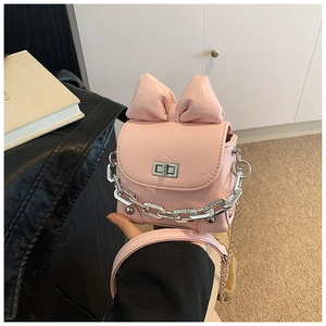Close-up of pink mini bow box bag with silver chain strap and metallic twist lock