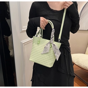 Light green woven handbag with elegant floral silk scarf handle and long shoulder strap