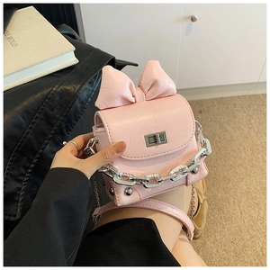 Detailed view of a pink bow mini box bag with embossed PU leather and silver chain strap