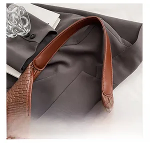 Detail shot of woven leather shoulder bag with smooth strap and neat stitching texture