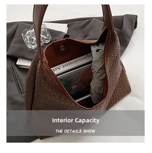 Detail of spacious interior capacity in brown woven hobo bag with books and umbrella