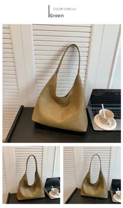 Detail of green woven hobo bag with long strap against a minimalist office background
