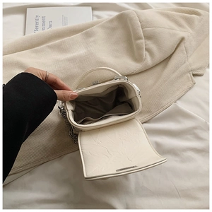 Detail view of mini off-white box bag showing interior pocket and silver chain strap