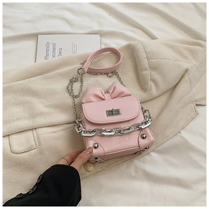 Detailed view of pink bow box bag with silver twist lock and textured finish