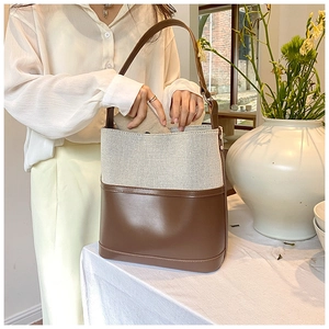Detail of vintage canvas bucket bag showing inner space for wallet on a sunny dining table