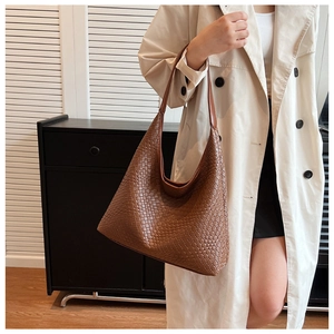 Detail of premium brown woven leather texture on a spacious tote hobo shoulder bag