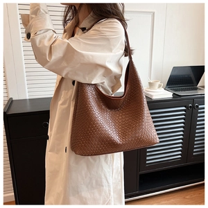 Detailed close-up of brown woven leather hobo bag showing large capacity and texture