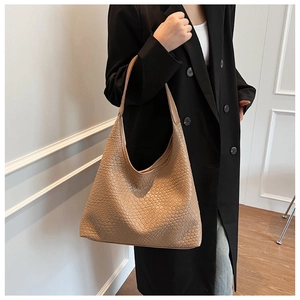 Detail of khaki woven hobo tote bag featuring intricate checkerboard texture on shoulder