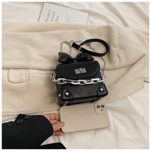 Detailed view of black bow crossbody box bag with silver hardware and chain strap
