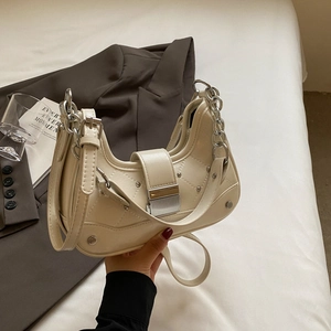 Chic cream croissant bag with diamond quilting, silver rivets, and metallic chain handle