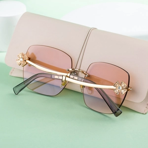 Detail of rimless sunglasses with gradient lenses and rhinestone flower accents on side