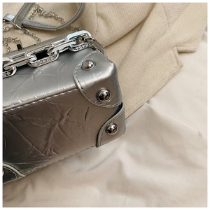 Detailed close-up of the silver textured mini box bag with metallic rivets and chain