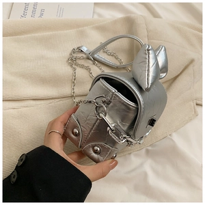 Detailed close-up of a silver mini box bag with rabbit ear design and chain strap