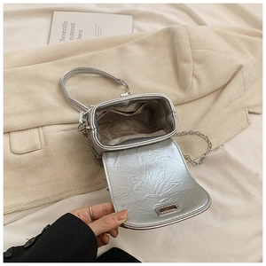 Top view of silver bow box bag showing internal compartment and metallic pleated texture