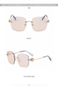 Close-up of frameless sunglasses with gold metal clover diamond hinge and light brown lens