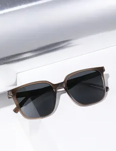 Detail view of translucent brown square sunglasses with black polarized lenses on a white step