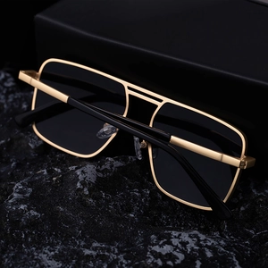 Detailed close-up of retro square double-bridge sunglasses with gold metal frame