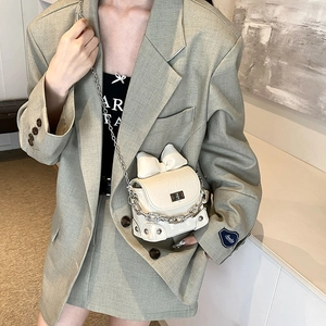 Chic white bow box crossbody bag with silver chain strap shown on a female model
