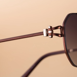Nahaufnahme von Metallscharnier und rutschfestem Bügel an bronzener Luxus-Sonnenbrille