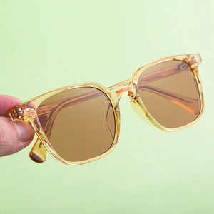 Detail of vintage square amber frame sunglasses with metal hinge and brown lenses