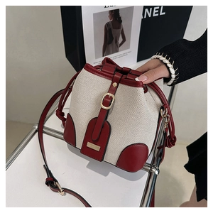 Detail of retro bucket bag with cream canvas and red leather contrast stitching