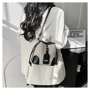 Detail of canvas bucket bag with black leather trim and drawstring in artistic shadow