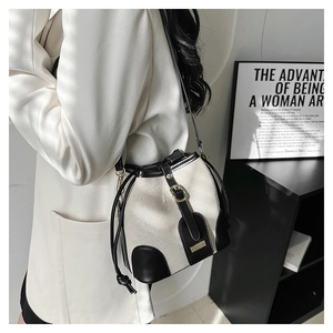 Detail of vintage canvas bucket bag with contrast leather trim and drawstring closure