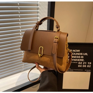 Detail view of vintage brown handbag featuring spliced PU leather and suede texture