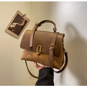 Detail of vintage brown tote bag showing smooth leather and suede texture contrast