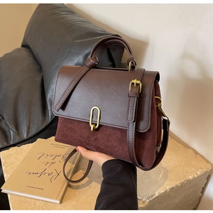 Detail of vintage coffee shoulder bag showing leather textures and gold hardware