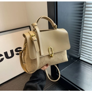 Detail of khaki crossbody bag featuring matte suede texture and gold U-shaped metal lock