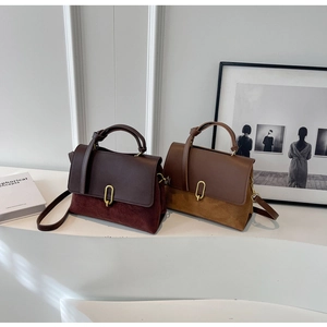 Detail of two-tone leather handbags with gold metal buckles and contrasting textures