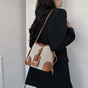 Retro canvas and brown leather bucket bag shown on model for casual spring fashion
