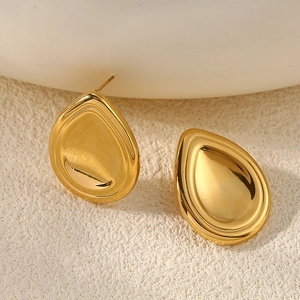 Detailed view of polished golden water drop stud earrings on a minimalist white background