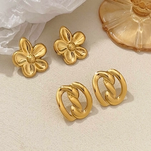 Polished 18k gold plated flower and oval earrings set on a minimalist background